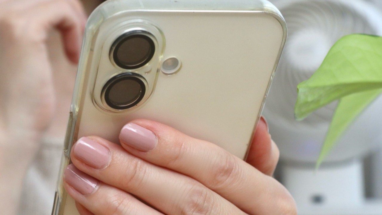 スマートフォンを見ながら考える女性