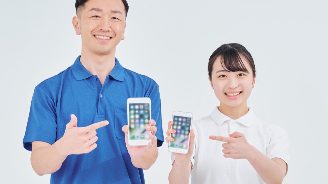 スマートフォンを持つ店舗スタッフ